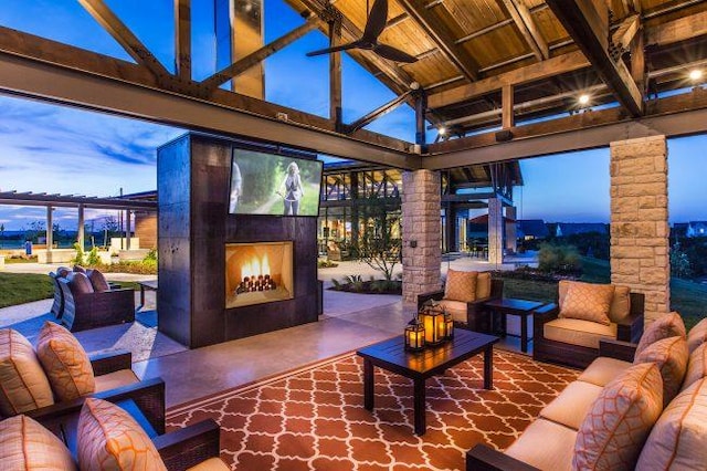 patio terrace at dusk featuring an outdoor living space with a fireplace