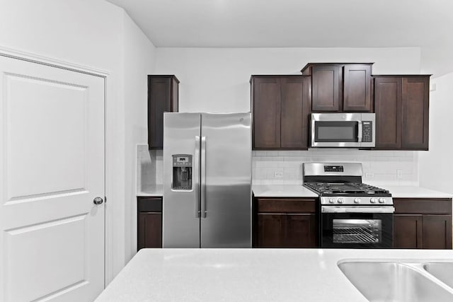 3201 Fresh Spring Rd, Pflugerville, TX 78660 - kitchen featuring stainless steel appliances, dark brown cabinets, light countertops, and backsplash