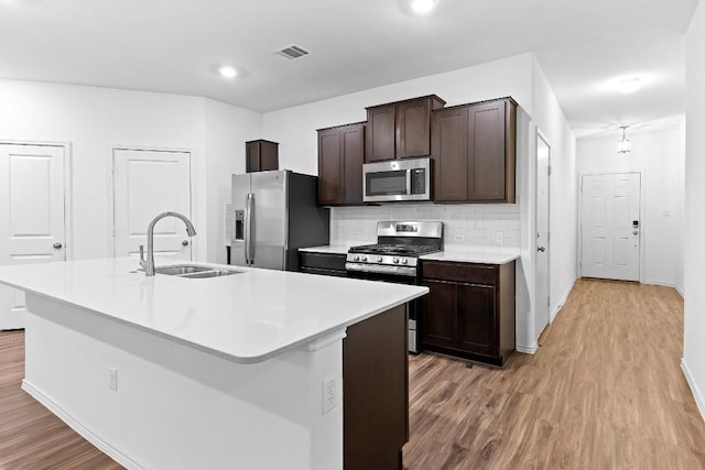 3201 Fresh Spring Rd, Pflugerville, TX 78660 - kitchen featuring stainless steel appliances, a sink, light wood finished floors, baseboards, and recessed lighting