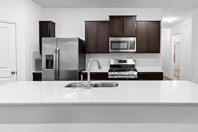 3201 Fresh Spring Rd, Pflugerville, TX 78660 - kitchen with stainless steel appliances, a sink, dark brown cabinetry, and backsplash