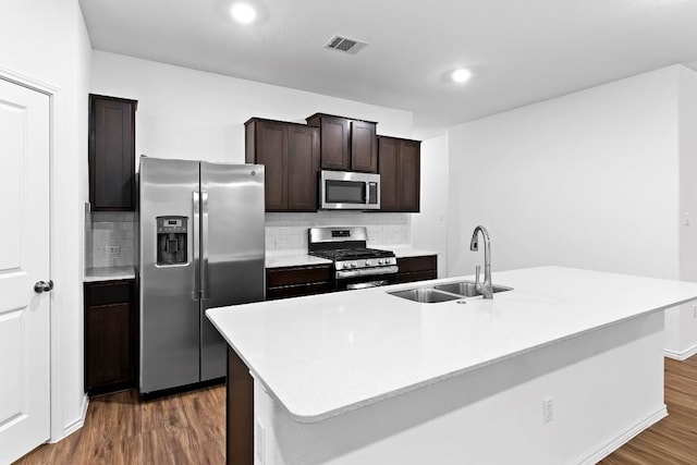 3201 Fresh Spring Rd, Pflugerville, TX 78660 - kitchen featuring appliances with stainless steel finishes, a sink, dark wood finished floors, tasteful backsplash, and dark brown cabinetry