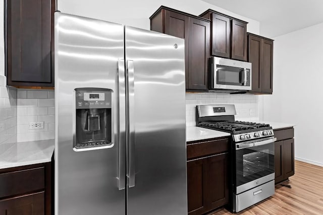 3201 Fresh Spring Rd, Pflugerville, TX 78660 - kitchen with stainless steel appliances, backsplash, dark brown cabinets, and light countertops