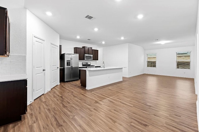 3201 Fresh Spring Rd, Pflugerville, TX 78660 - kitchen featuring stainless steel appliances, open floor plan, backsplash, an island with sink, and a sink