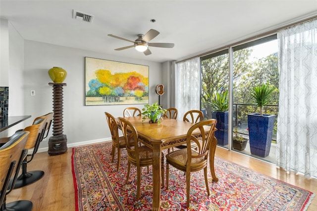 dining room featuring light hardwood / wood-style flooring, a wealth of natural light, expansive windows, and ceiling fan