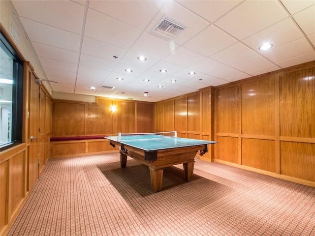 game room featuring light carpet and wooden walls