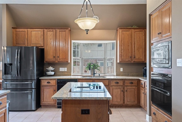 kitchen with decorative light fixtures, sink, a center island, light tile patterned floors, and black appliances