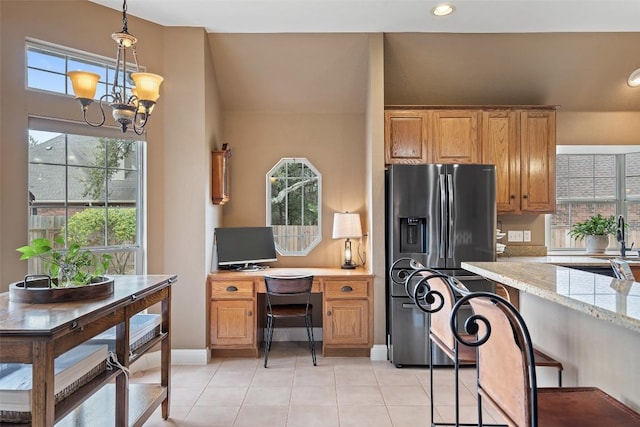 kitchen with pendant lighting, a chandelier, light tile patterned floors, light stone countertops, and fridge with ice dispenser