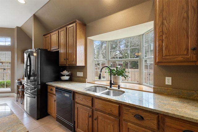 kitchen with light stone counters, sink, black appliances, and light tile patterned flooring