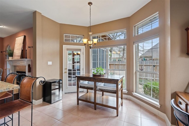 tiled dining space featuring an inviting chandelier and plenty of natural light