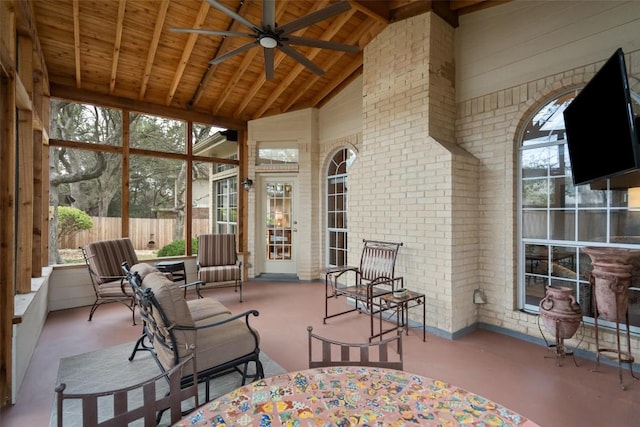 sunroom / solarium featuring ceiling fan, vaulted ceiling with beams, and wood ceiling