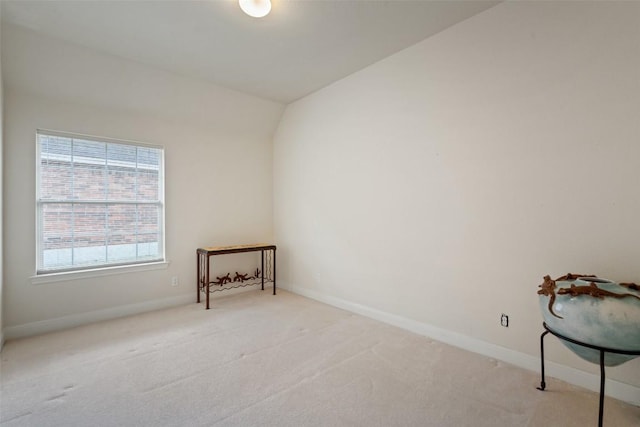 carpeted empty room featuring lofted ceiling