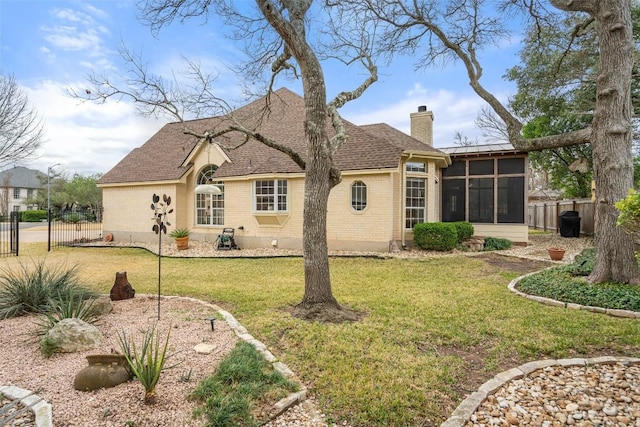 back of property with a yard and a sunroom