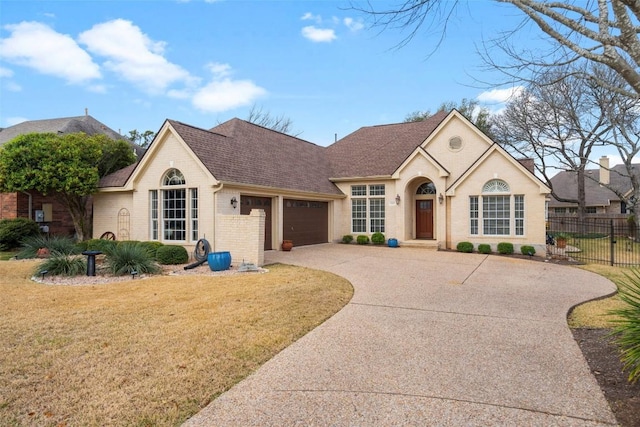 ranch-style home with a garage and a front lawn