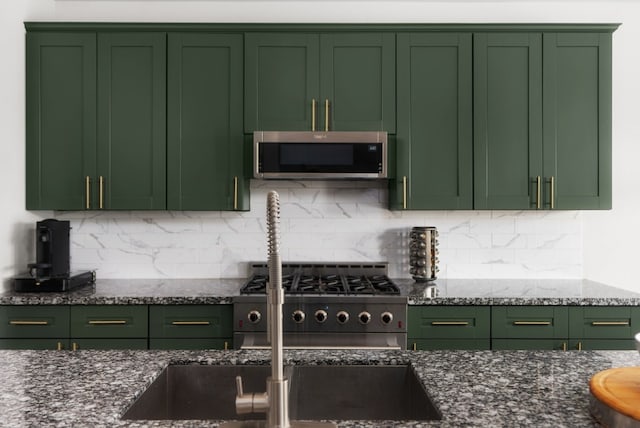 kitchen with green cabinets and appliances with stainless steel finishes