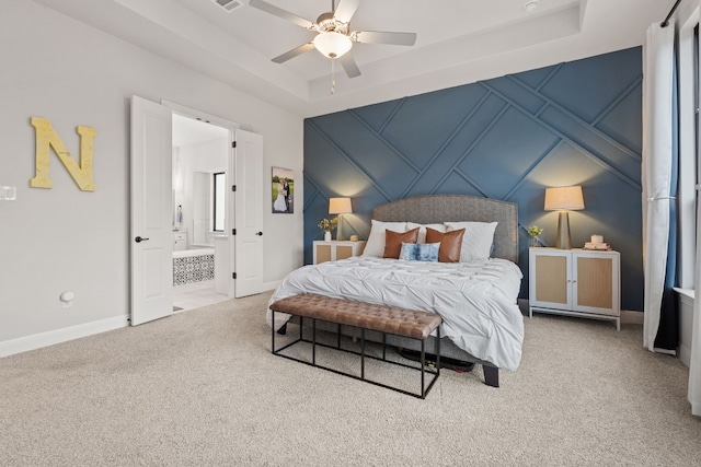 208 Tovas Secret Cv, Georgetown, TX 78628 - carpeted bedroom with a raised ceiling, a decorative wall, a ceiling fan, and connected bathroom