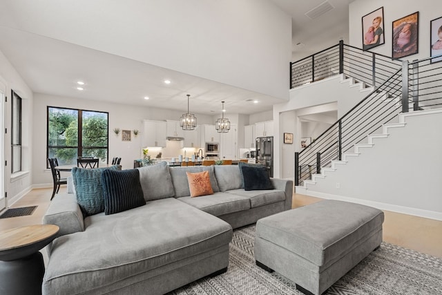 208 Tovas Secret Cv, Georgetown, TX 78628 - living area with stairway, recessed lighting, a chandelier, and light wood finished floors