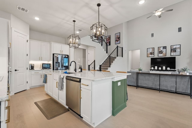 208 Tovas Secret Cv, Georgetown, TX 78628 - kitchen with appliances with stainless steel finishes, light wood-type flooring, white cabinets, recessed lighting, and light stone countertops