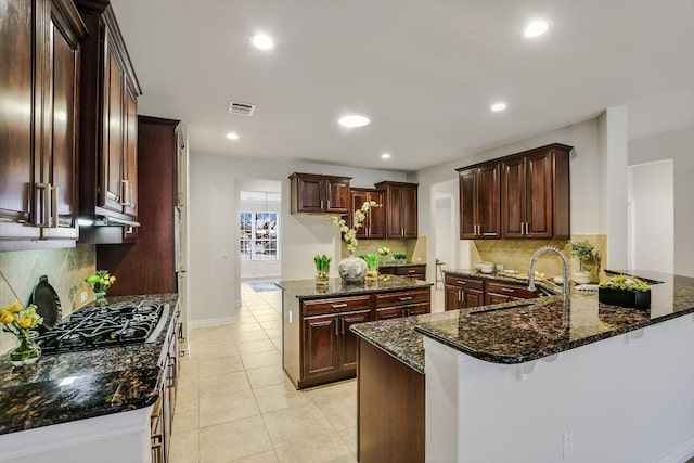 317 Yellow Rose Trl, Georgetown, TX 78633 - kitchen with a sink, black gas cooktop, a peninsula, decorative backsplash, and recessed lighting