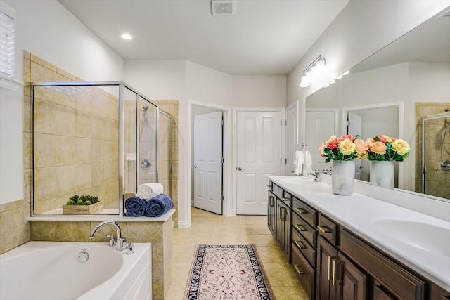 317 Yellow Rose Trl, Georgetown, TX 78633 - full bath with double vanity, a shower stall, a garden tub, and tile patterned floors