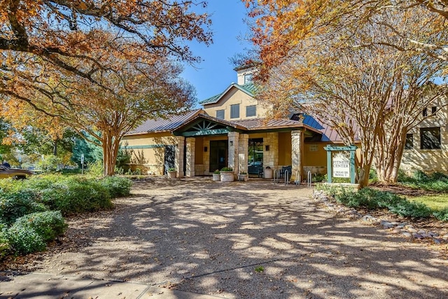 317 Yellow Rose Trl, Georgetown, TX 78633 - view of front of house featuring a standing seam roof, stone siding, covered porch, and metal roof