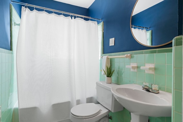 full bathroom featuring toilet, sink, shower / bath combo with shower curtain, and tile walls