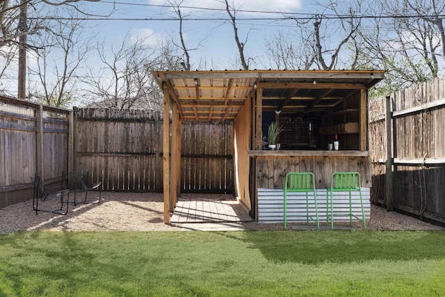 view of outdoor structure with exterior bar and a lawn