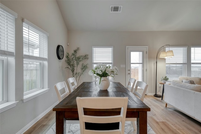 dining room with lofted ceiling and light hardwood / wood-style flooring