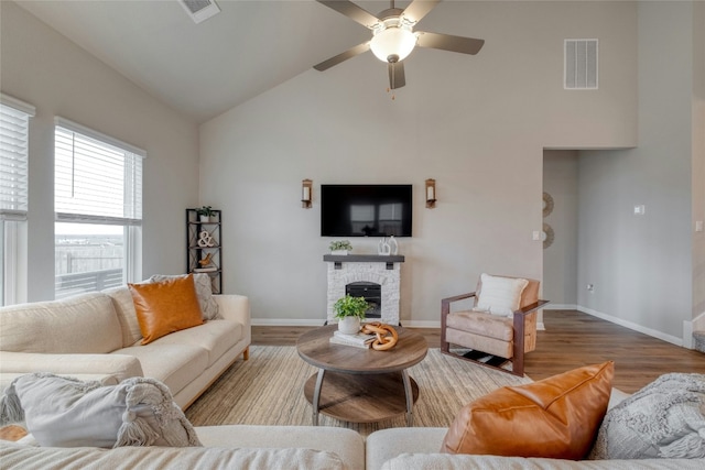 living room with ceiling fan, high vaulted ceiling, and light wood-type flooring