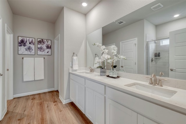 bathroom featuring wood-type flooring, an enclosed shower, and vanity