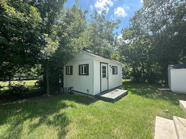 view of outbuilding with fence and an outbuilding