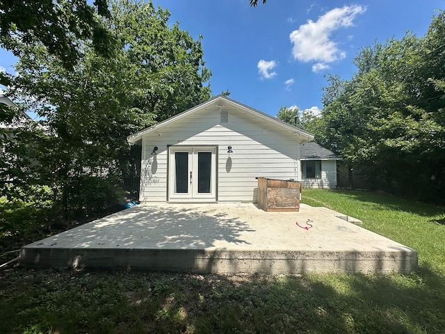 rear view of house with a patio, a lawn, and french doors