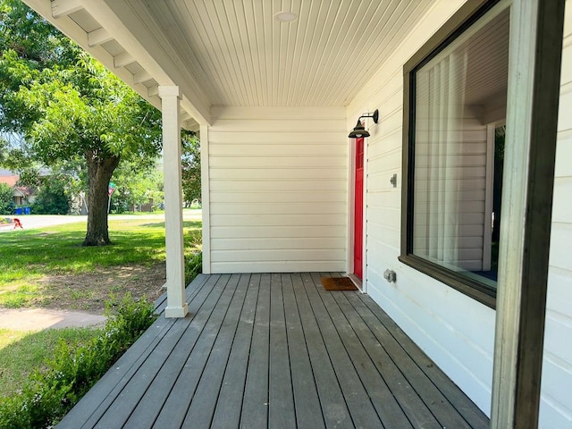 wooden deck with covered porch and a yard