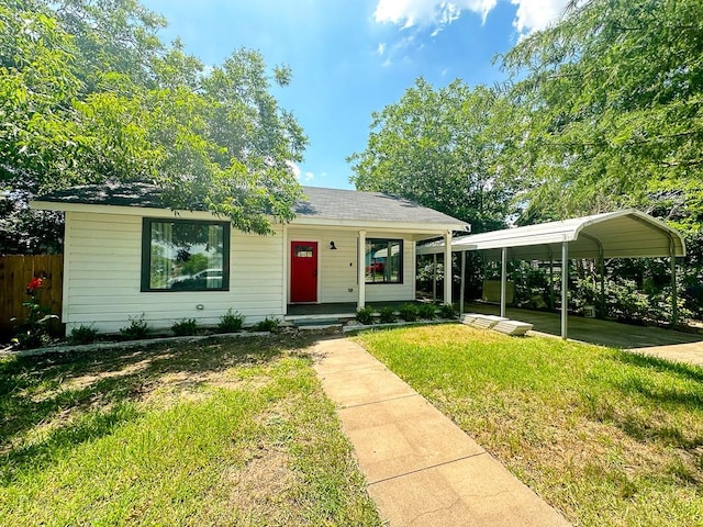 view of front of house featuring a front yard, fence, and a detached carport