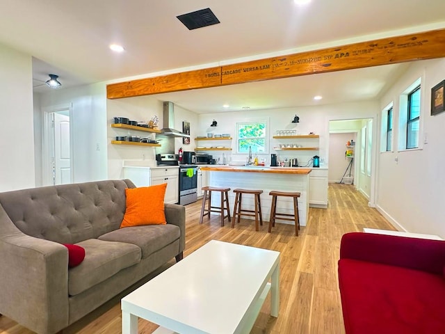 living room with light wood-type flooring, beam ceiling, baseboards, and recessed lighting