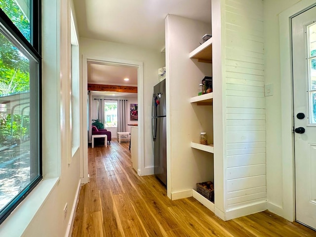 hallway with wood-type flooring and baseboards