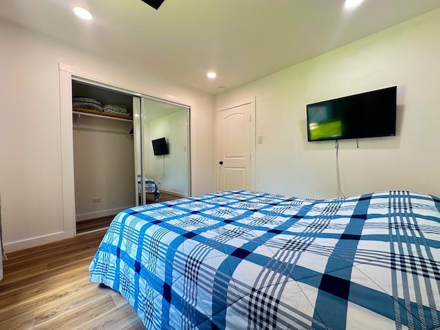 bedroom with baseboards, a closet, recessed lighting, and wood finished floors
