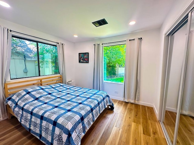 bedroom featuring recessed lighting, wood finished floors, and multiple windows