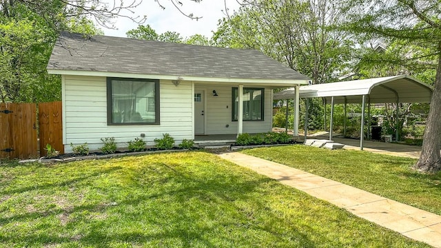 view of front of property with a front lawn, fence, a shingled roof, a porch, and a carport