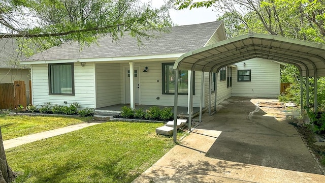 view of front facade with fence, a shingled roof, a porch, a front yard, and driveway