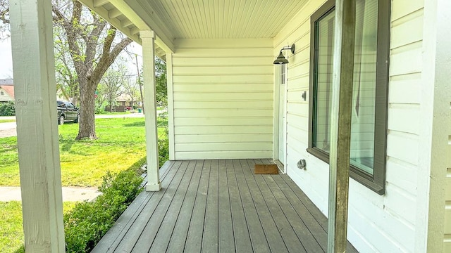 wooden deck with covered porch and a yard