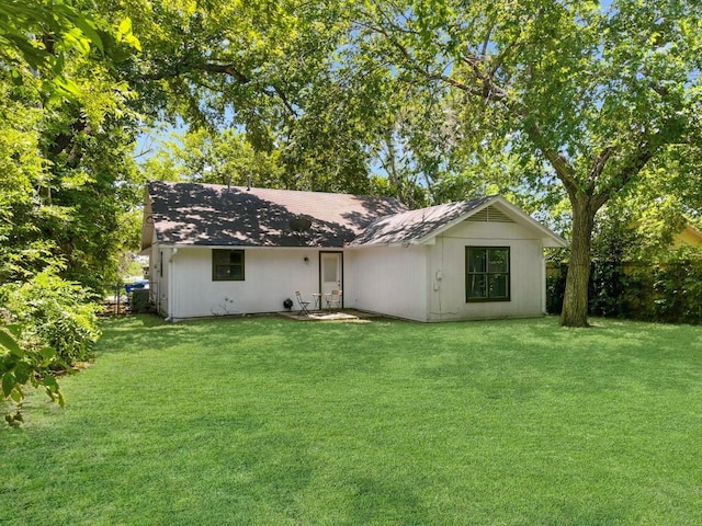 rear view of property featuring a yard