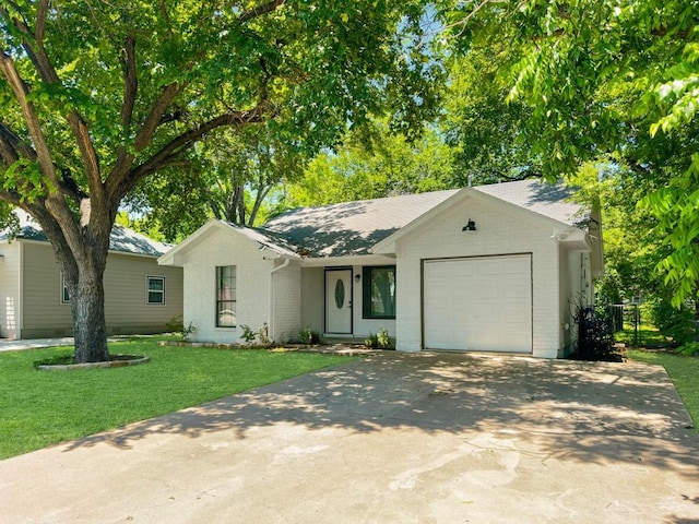 ranch-style home featuring a garage and a front lawn