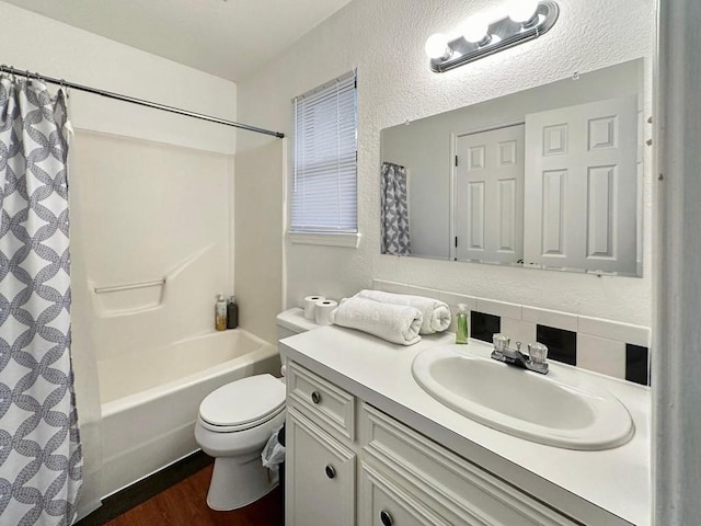 full bathroom with shower / bath combo, hardwood / wood-style floors, vanity, and toilet