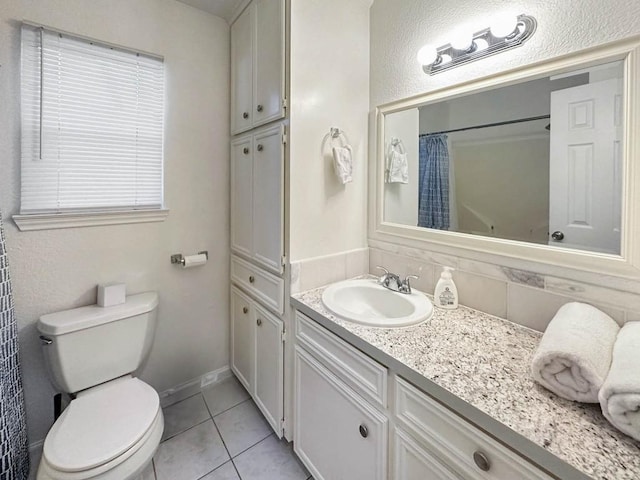 bathroom featuring vanity, a shower with shower curtain, tile patterned floors, and toilet