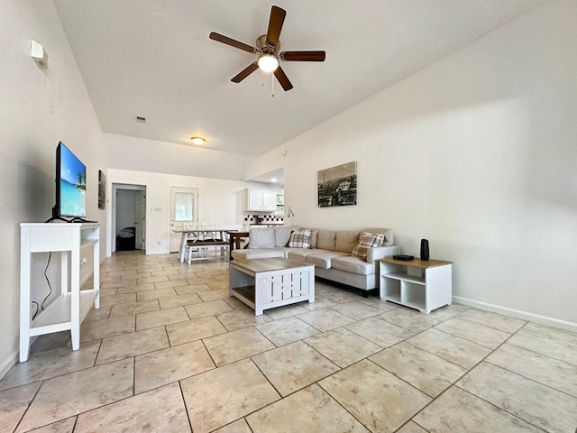 living room featuring ceiling fan, vaulted ceiling, and light tile patterned floors