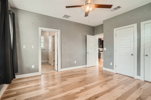 unfurnished bedroom with connected bathroom, ceiling fan, and light wood-type flooring