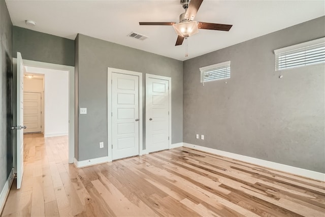 unfurnished bedroom with light hardwood / wood-style floors, a closet, and ceiling fan