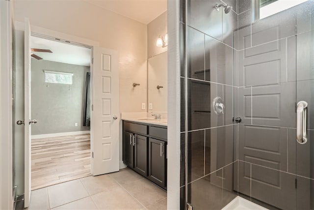 bathroom with tile patterned flooring, vanity, and a shower with door