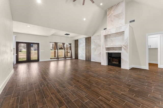 unfurnished living room featuring visible vents, french doors, wood finish floors, and a high end fireplace