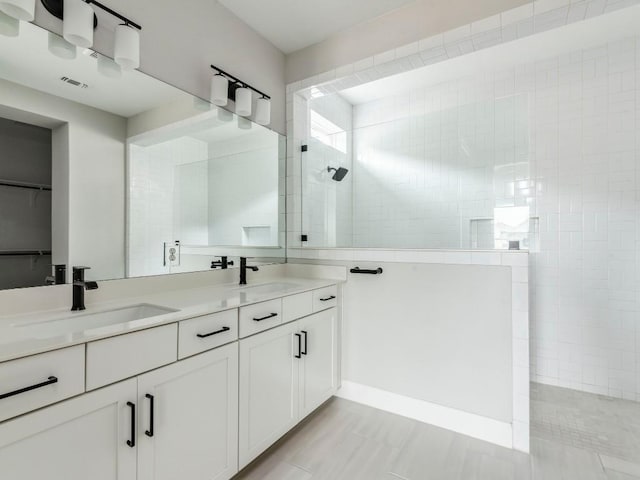 bathroom with tiled shower and vanity